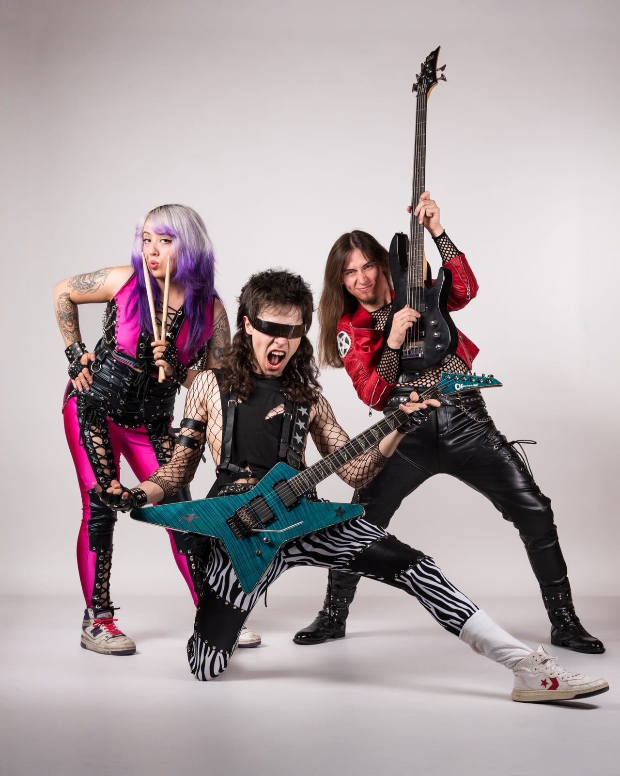 FORCE: los tres integrantes posando con sus instrumentos y vestuario glam